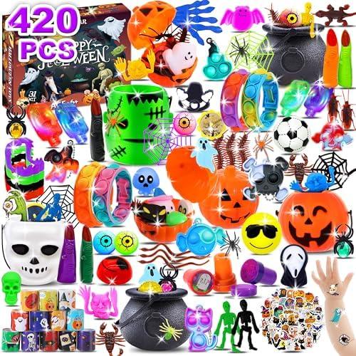 A colorful assortment of 420 Halloween-themed items, including plastic pumpkins, skulls, ghosts, spiders, and various toys, all arranged around a Halloween game box.